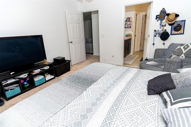 bedroom with light carpet and connected bathroom