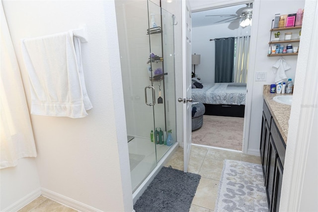 bathroom with tile patterned floors, ceiling fan, a shower with door, and vanity