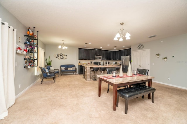 dining space with light carpet, a notable chandelier, and sink