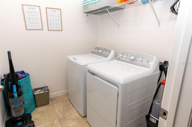 laundry room with independent washer and dryer and light tile patterned floors