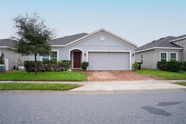 single story home with central AC, a front lawn, and a garage