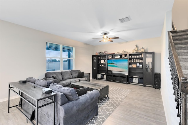 living room featuring wood-type flooring and ceiling fan