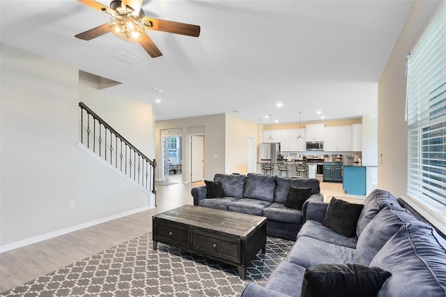 living room featuring light wood-type flooring and ceiling fan