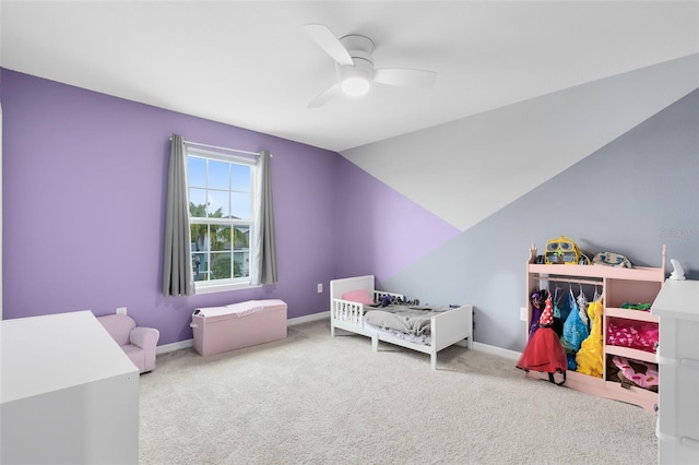 carpeted bedroom featuring ceiling fan, a crib, and lofted ceiling