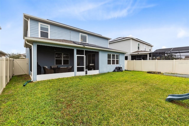 rear view of property featuring a sunroom and a yard