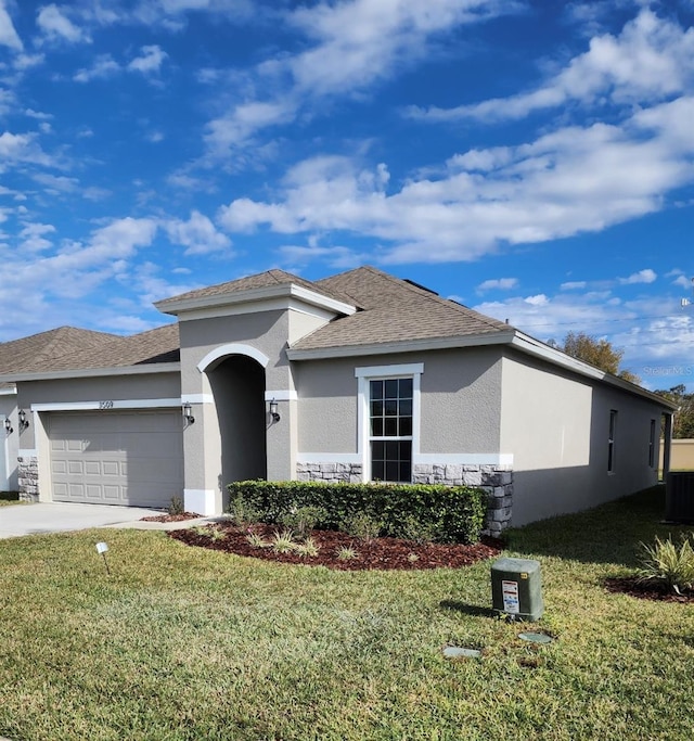 view of front of home with a front lawn and a garage