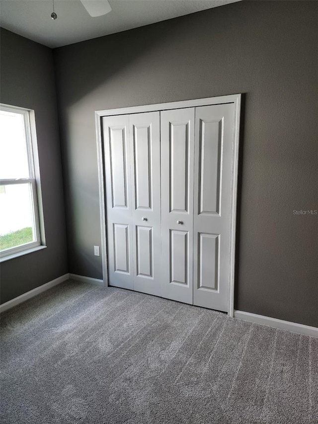 unfurnished bedroom featuring carpet flooring and a closet