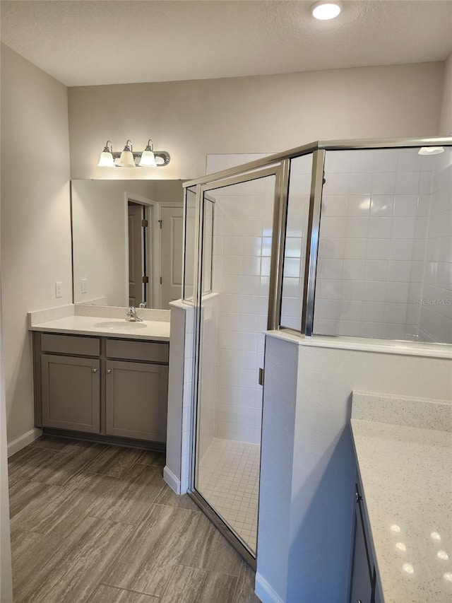 bathroom featuring hardwood / wood-style floors, vanity, and an enclosed shower