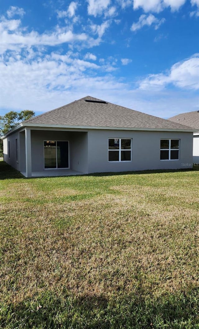 back of house featuring a lawn