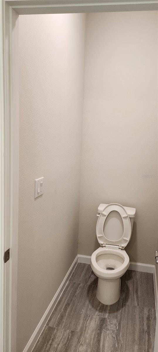 bathroom featuring toilet and hardwood / wood-style flooring