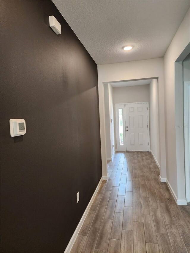 doorway to outside featuring a textured ceiling