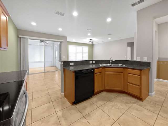 kitchen with dishwasher, stove, dark stone counters, sink, and light tile patterned floors