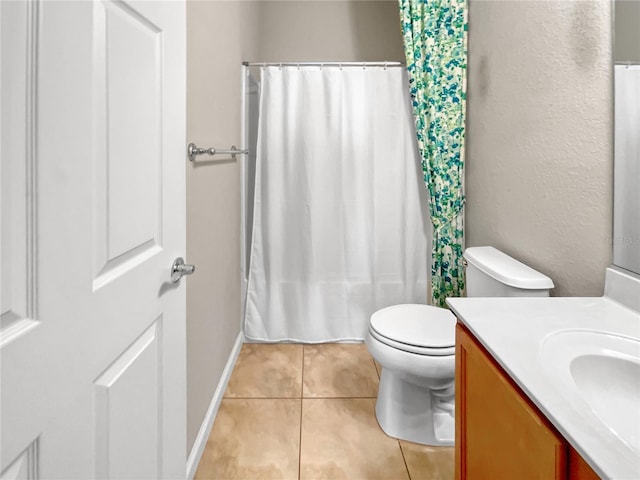 bathroom with tile patterned flooring, vanity, and toilet