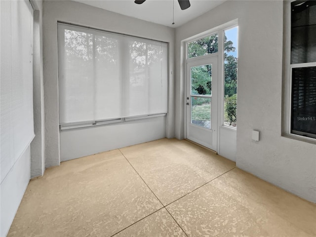 unfurnished sunroom featuring ceiling fan