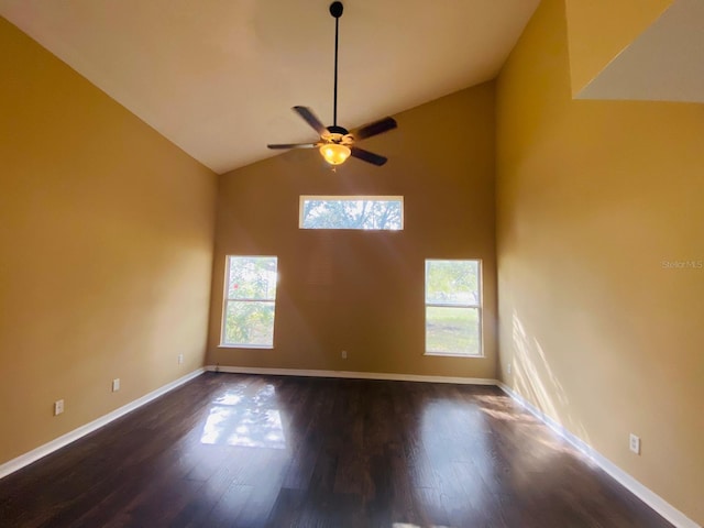 spare room with dark hardwood / wood-style flooring, vaulted ceiling, and ceiling fan