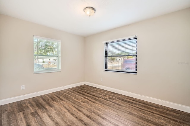 empty room with dark hardwood / wood-style flooring