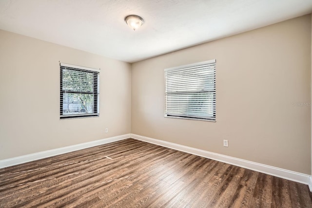 spare room with dark wood-type flooring