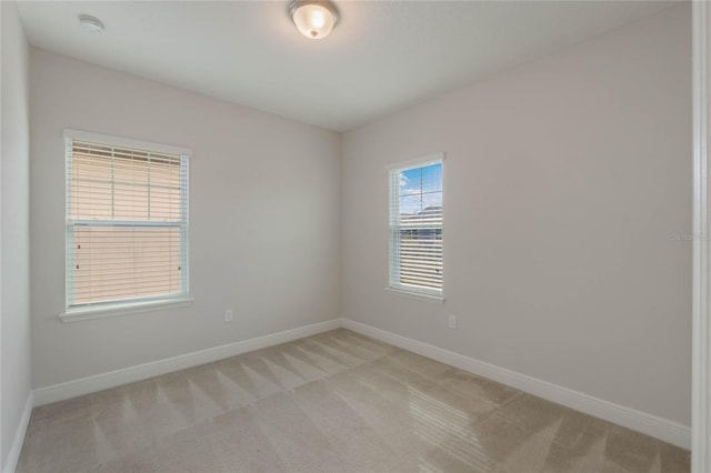 spare room featuring light carpet