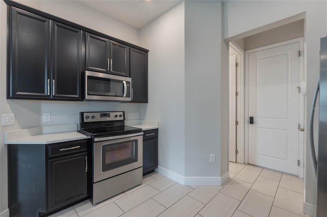 kitchen with light tile patterned floors and stainless steel appliances