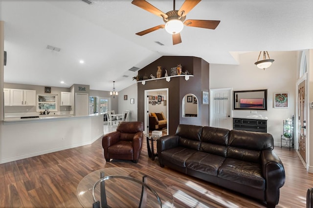 living room with sink, ceiling fan with notable chandelier, wood-type flooring, and lofted ceiling