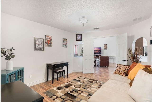 living room with a textured ceiling and hardwood / wood-style flooring