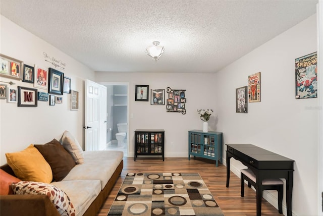 living room with built in features, hardwood / wood-style floors, and a textured ceiling