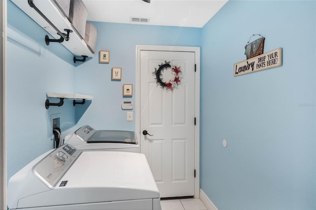 laundry room featuring light tile patterned floors and washer and clothes dryer