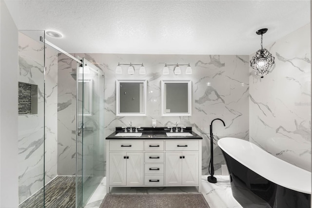 bathroom with a textured ceiling, vanity, and independent shower and bath