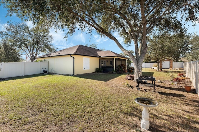 back of property featuring a lawn and a sunroom