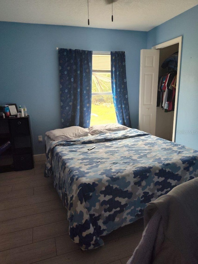 bedroom with dark hardwood / wood-style floors and a closet