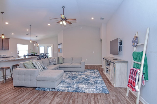 living room featuring vaulted ceiling, light hardwood / wood-style flooring, ceiling fan, and sink