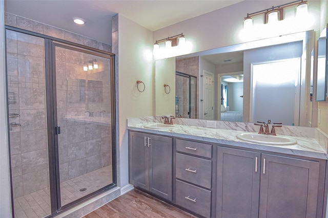 bathroom with vanity, an enclosed shower, and wood-type flooring