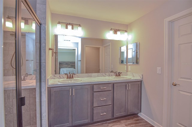 bathroom featuring hardwood / wood-style floors, vanity, and a shower with shower door