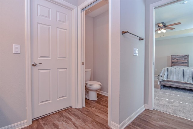 bathroom with hardwood / wood-style floors, ceiling fan, and toilet