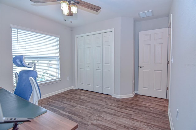 unfurnished office with ceiling fan, wood-type flooring, and a wealth of natural light