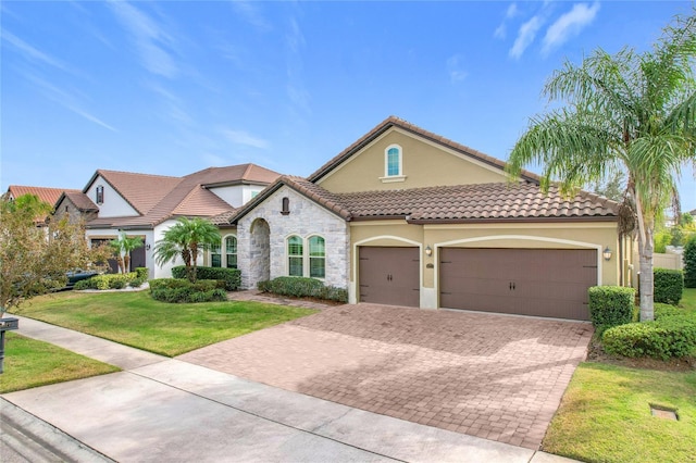 mediterranean / spanish house featuring a front yard and a garage