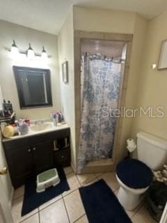 bathroom featuring toilet, vanity, tile patterned floors, and curtained shower