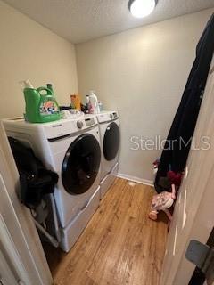 laundry room featuring washer and dryer and light hardwood / wood-style flooring