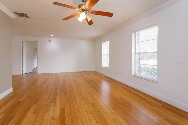 empty room featuring ceiling fan, light hardwood / wood-style flooring, plenty of natural light, and ornamental molding