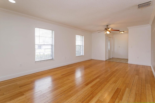 empty room featuring a textured ceiling, light hardwood / wood-style flooring, ceiling fan, and ornamental molding