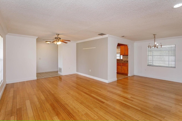 unfurnished living room featuring a textured ceiling, ceiling fan with notable chandelier, light hardwood / wood-style flooring, and crown molding