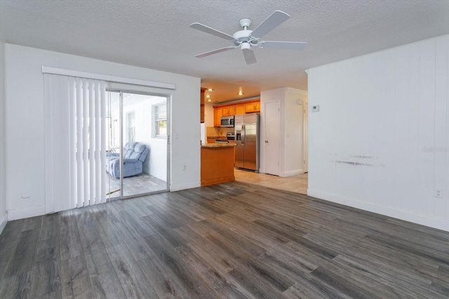 unfurnished living room with a textured ceiling, ceiling fan, and dark hardwood / wood-style floors