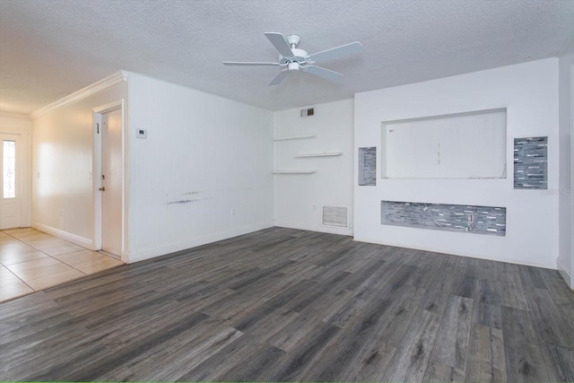 unfurnished living room with ceiling fan, dark hardwood / wood-style flooring, ornamental molding, and a textured ceiling