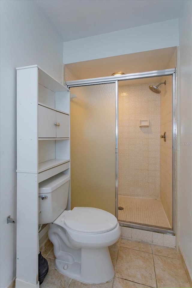 bathroom featuring tile patterned floors, toilet, and walk in shower