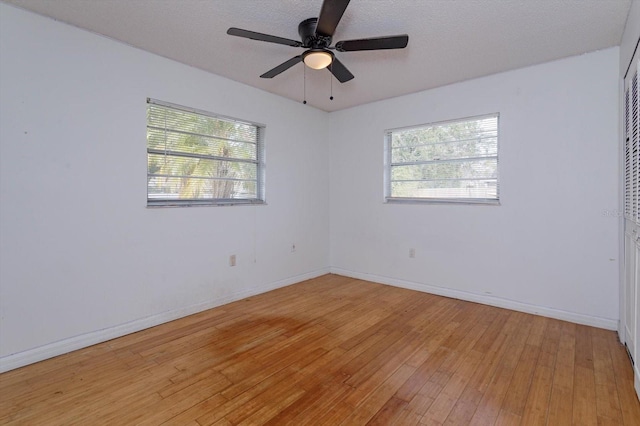 unfurnished room with light hardwood / wood-style flooring, ceiling fan, and a healthy amount of sunlight