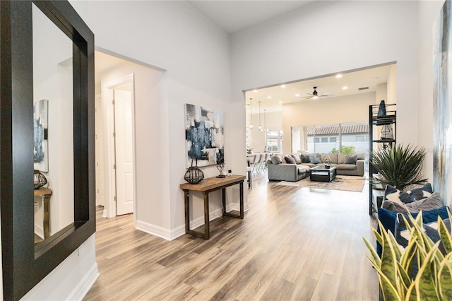 corridor with a towering ceiling and hardwood / wood-style flooring