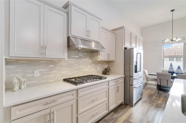 kitchen with backsplash, stainless steel appliances, wood-type flooring, white cabinetry, and hanging light fixtures