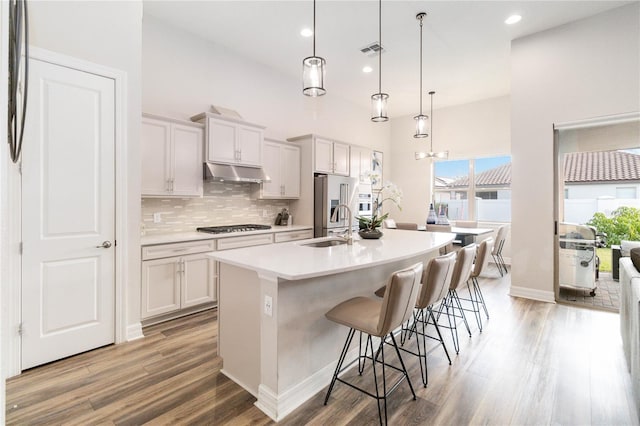 kitchen featuring pendant lighting, a center island with sink, a kitchen breakfast bar, and sink