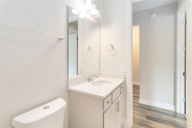 bathroom featuring vanity, hardwood / wood-style flooring, and toilet