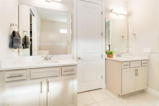 bathroom with tile patterned flooring, vanity, and tiled shower